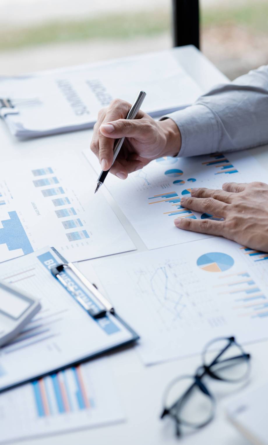 A female financier is reviewing company financial documents, monthly financial statement summary from the finance department. The concept of managing the company's finances for accuracy and growth.