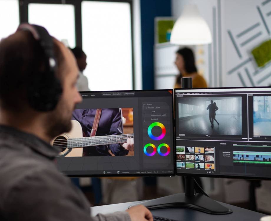 Videographer listening music on headphones editing creative movie using post production software working in business multimedia agency office. Artist man processing audio film montage on computer